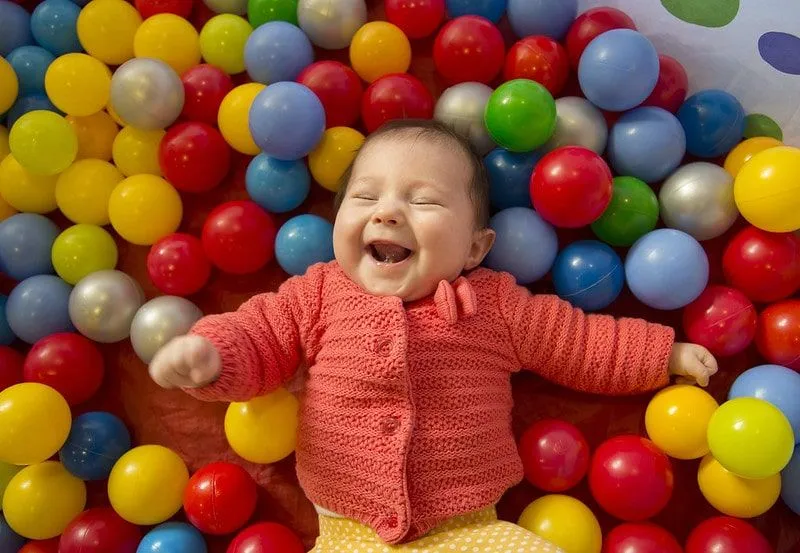 Бебе се смее в яма за топка