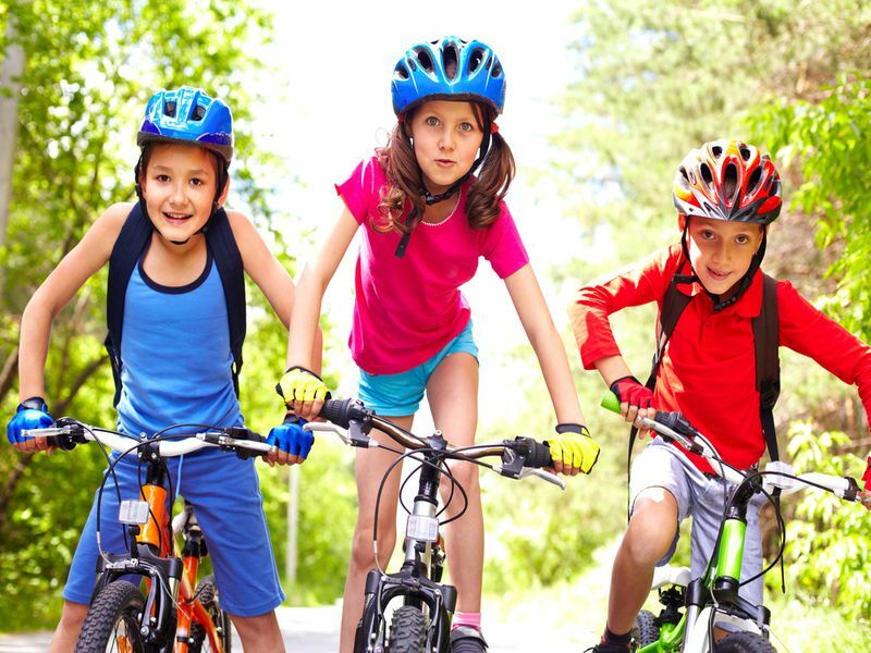 Kolm noort jalgratturit rattaga sõitmas