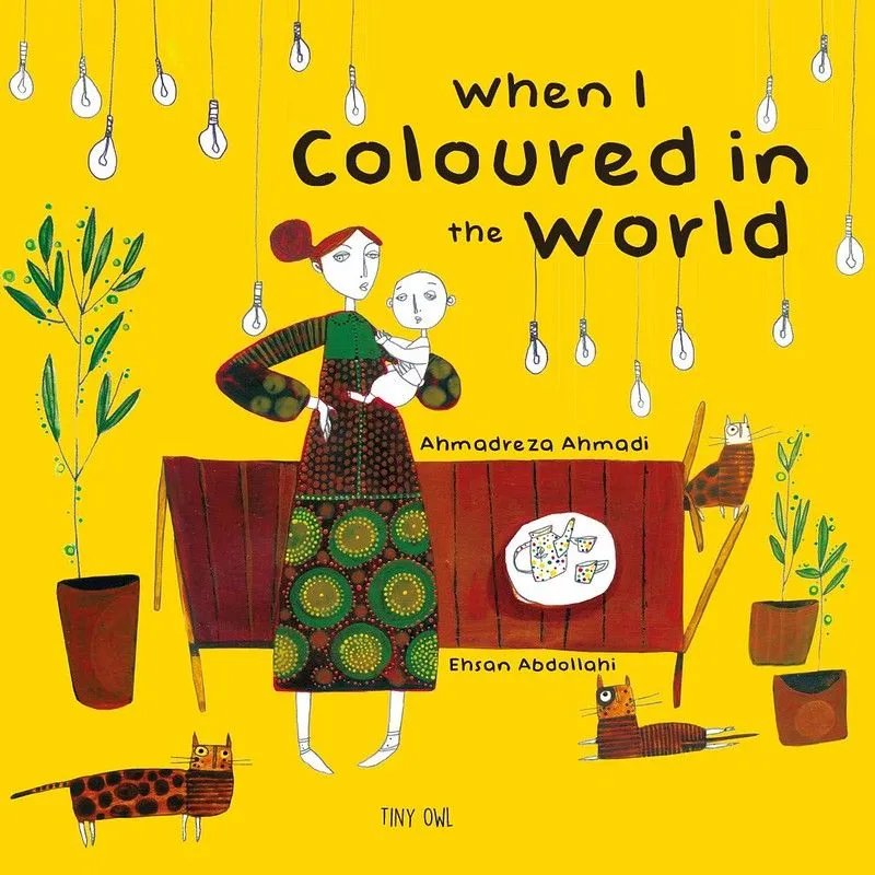 Forside av When I Colored In The World: en kvinne i mønstrede grønne og brune klær holder en baby ved hoften, som begge ikke har noen farge på kroppen. De er i et gult rom med brune møbler og tre brune katter.