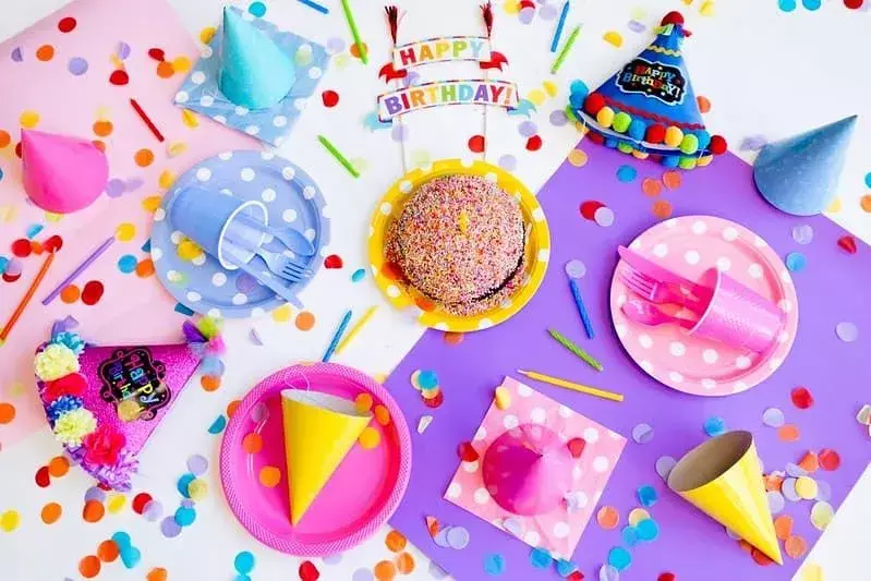 Rođendanska torta s posipom i šarenim party dekoracijama.