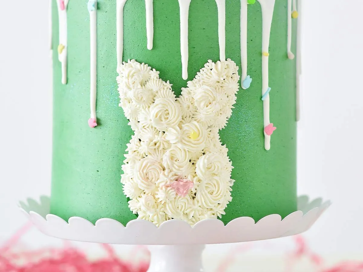 Siden av en grønn bursdagskake med hvit glasur i form av et kaninhode.