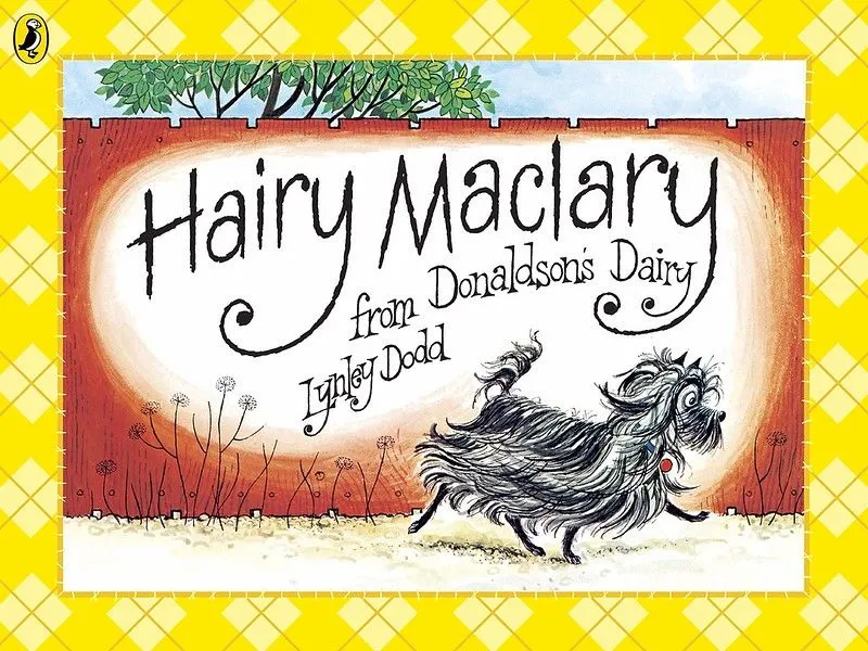 Cover of Hairy Maclary: en svart hund med lang pels går nedover en sti, med et høyt rødt gjerde bak seg.