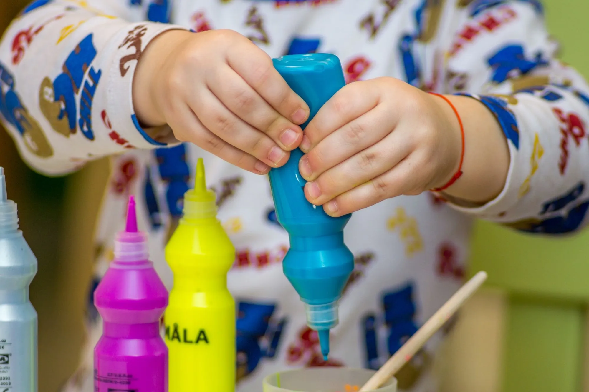 dítě mačkání lahvičky s barvou