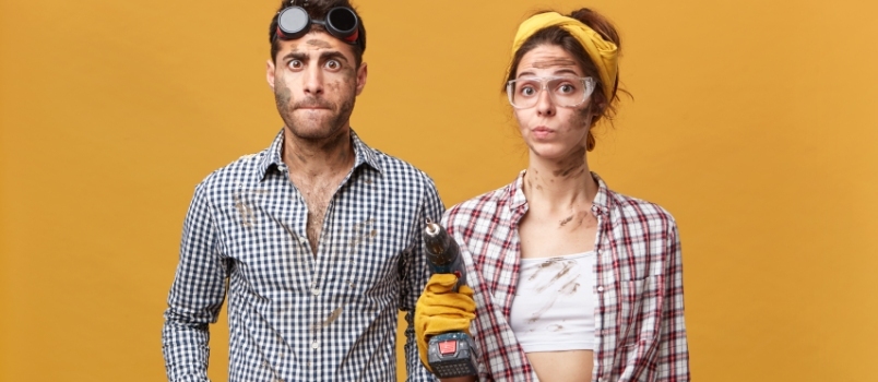 Expressão facial humana, homens e mulheres, foto interna, masculino, vestindo fantasia de eletricista, enquanto mulheres seguram uma furadeira com a parede de fundo amarelo isolada