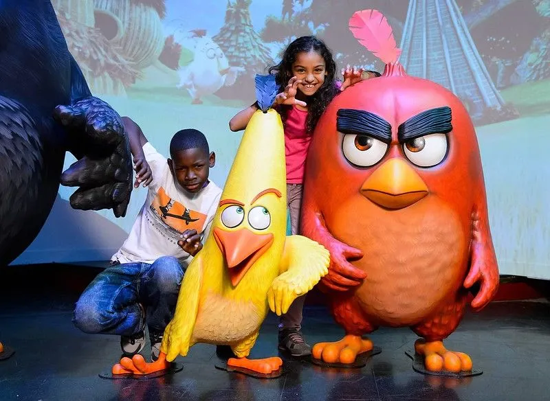 Madame Tussuds에서 두 명의 Angry Birds 캐릭터와 함께 포즈를 취하는 소년 소녀.