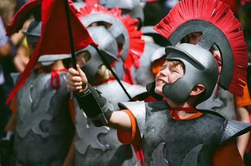 Ragazzini travestiti da soldati romani che si preparano ad andare in battaglia.