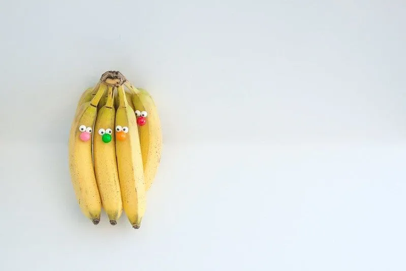 En haug med bananer med lune øyne sitter fast på å lage morsomme ansikter.