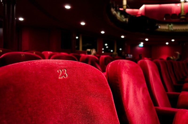 Perto dos assentos vermelhos do teatro.