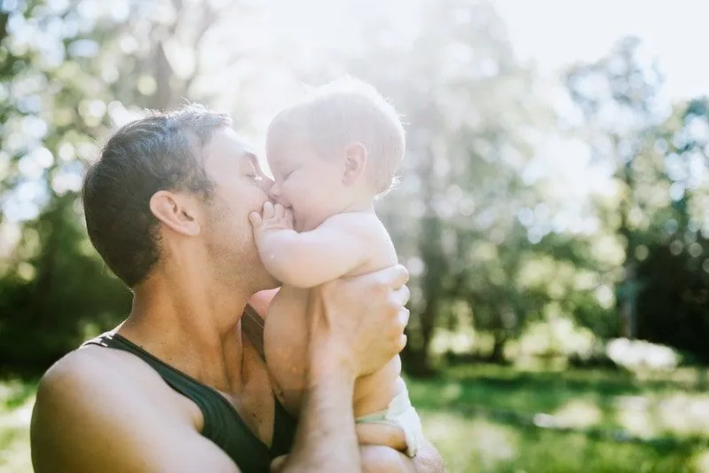Татко целува новородено момиченце