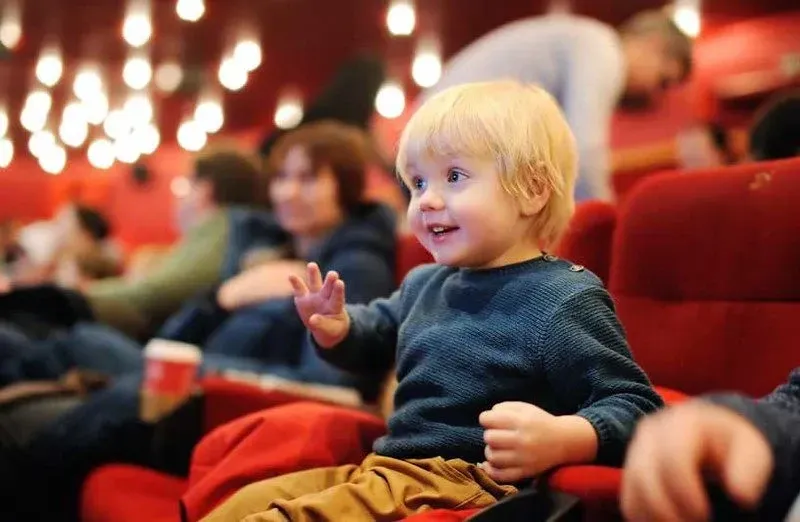 μικρό αγόρι στο θέατρο χαμογελώντας