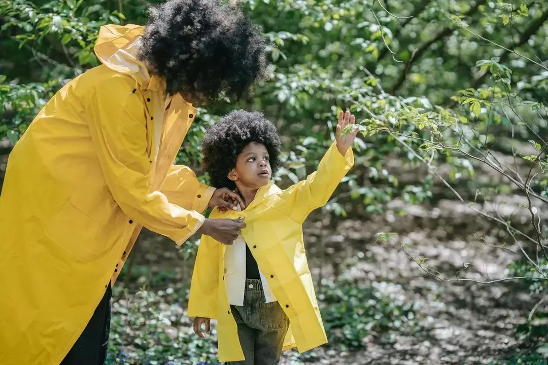 Maža mergaitė ir mama, vilkinčios geltonus švarkus miške