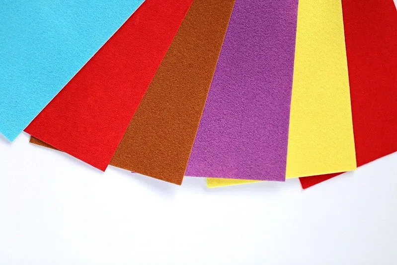 Pedaços de papel de feltro de cores diferentes se espalharam.