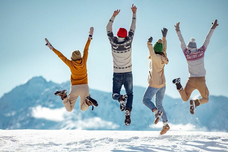 Sõbrad hüppavad rõõmsalt lumisel mäel
