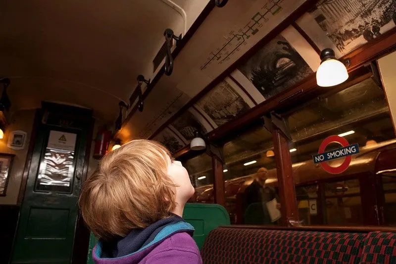 Chlapec při pohledu na displej ve starém vlaku v londýnském dopravním muzeu.