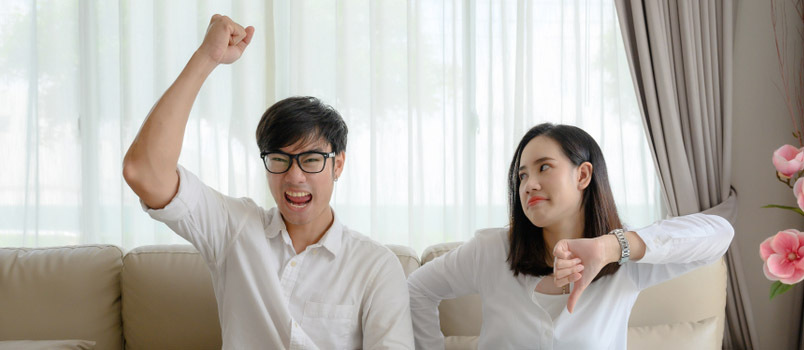 Esposa e marido discordam e discutem chateados ao assistir TV em casa