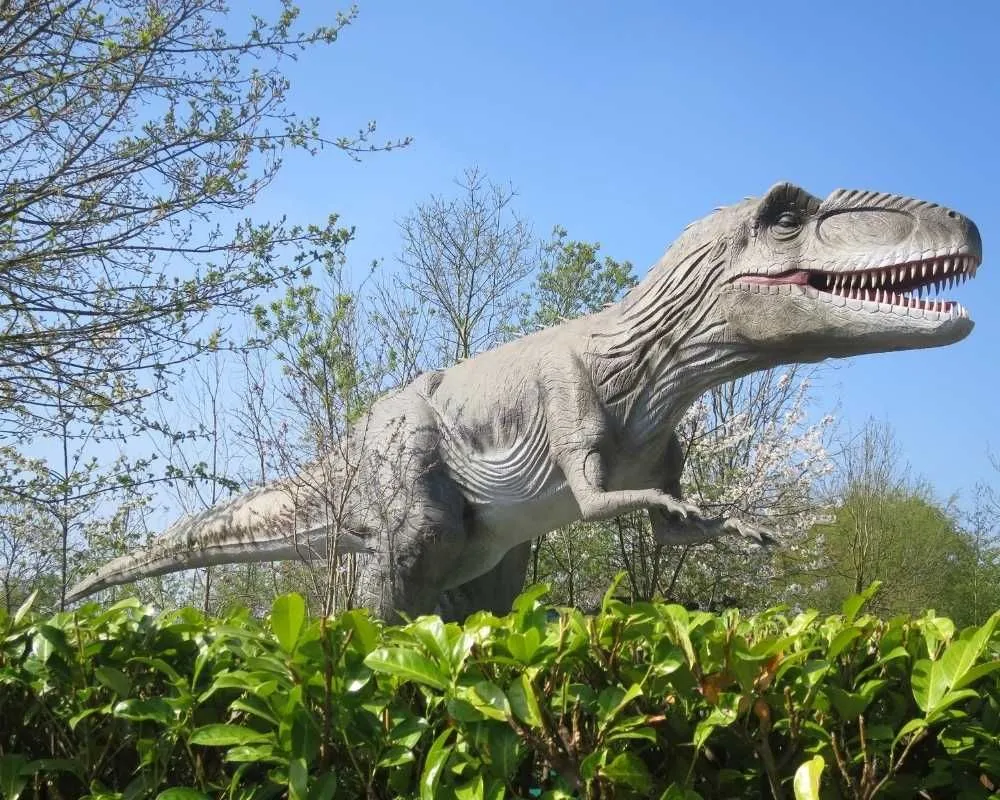Gigantozauras Guliverio žemėje, iškilęs virš krūmų.