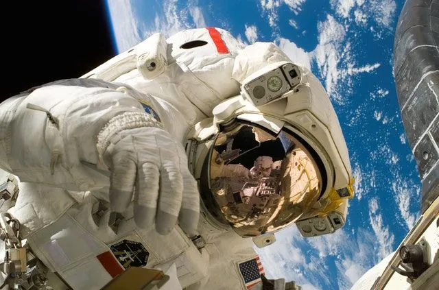 En astronaut i verdensrommet med jorden i sikte bak seg. 
