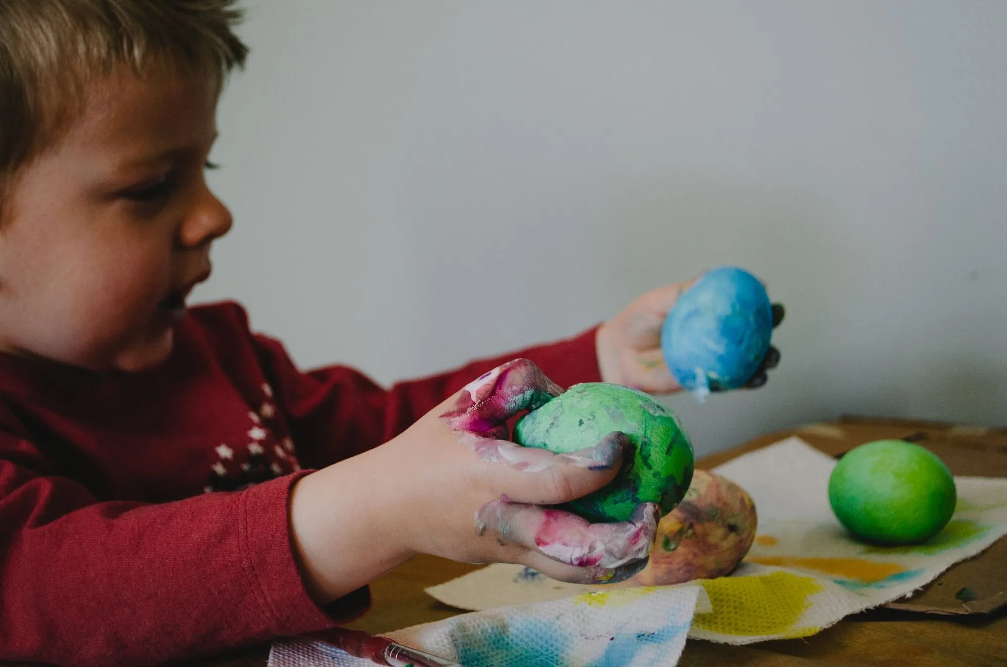 menino segurando bolas de massa de cores diferentes